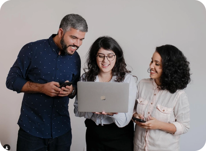 Foto do Eduardo, Duda e Marina olhando para um notebook.